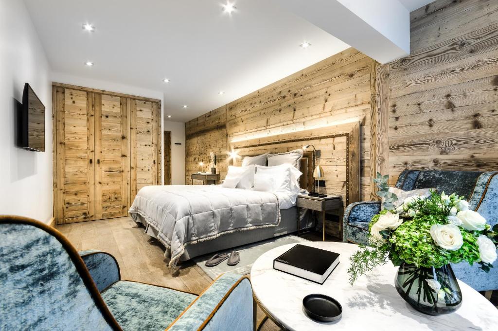 a bedroom with a bed and a table and chairs at Hôtel La Sivolière in Courchevel