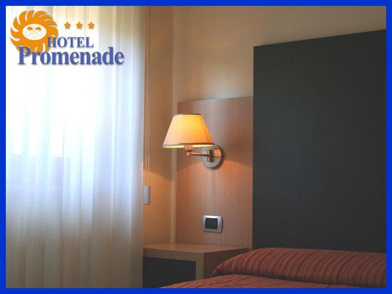 a bedroom with a bed and a light at Hotel Promenade in Porto SantʼElpidio