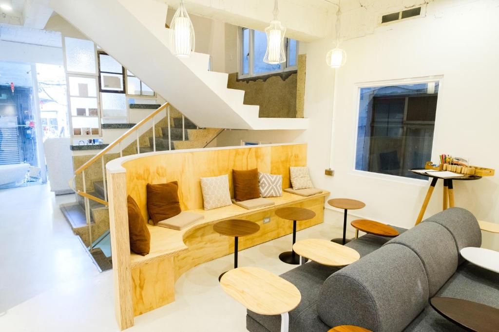 a living room with a couch and tables and a staircase at SSS Life Hotel in Tainan