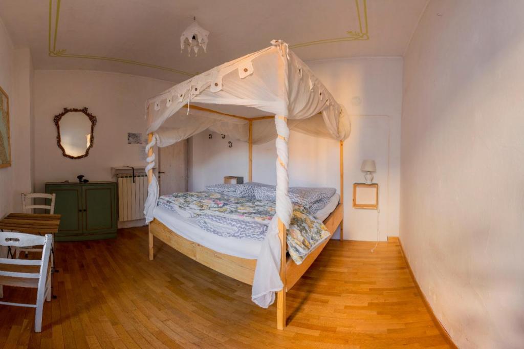 a bedroom with a canopy bed and a wooden floor at bnb Bergamo in Bergamo