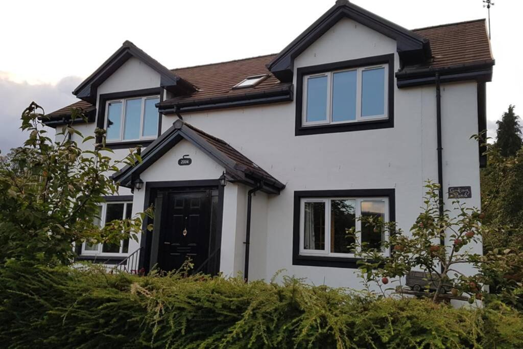 uma casa branca com uma porta preta e janelas em The Curling Pond, Dalmally Road, Inveraray em Inveraray