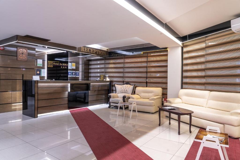 a living room with two couches and a table at Hotel De KOKA in Skopje