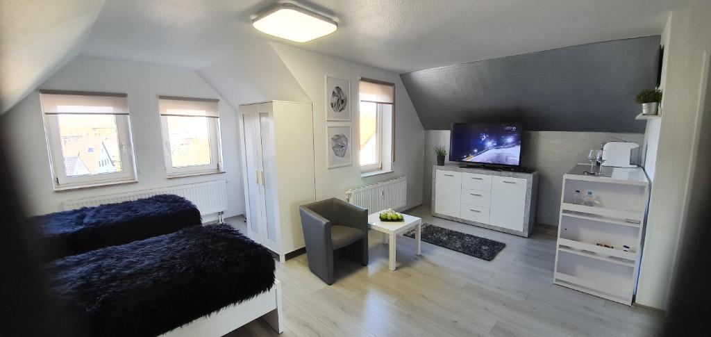 1 dormitorio con 1 cama y TV de pantalla plana en Unique Messe - Airport en Steinenbronn