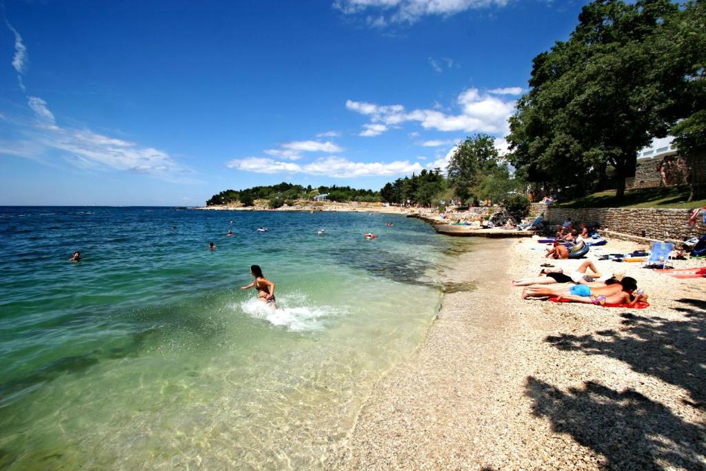 a group of people playing in the water at a beach at Hotel Istra Plava Laguna in Poreč