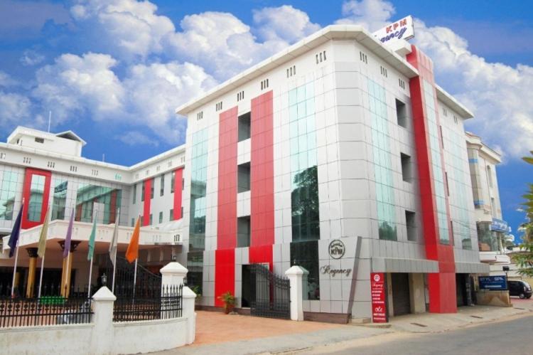 un edificio rojo y blanco en una calle de la ciudad en KPM Regency, en Palakkad