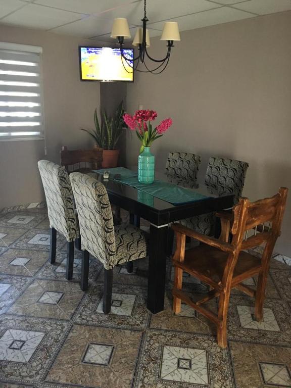 a dining room table with chairs and a vase of flowers at Ventanas al sur 2 in San Nicolás de los Arroyos
