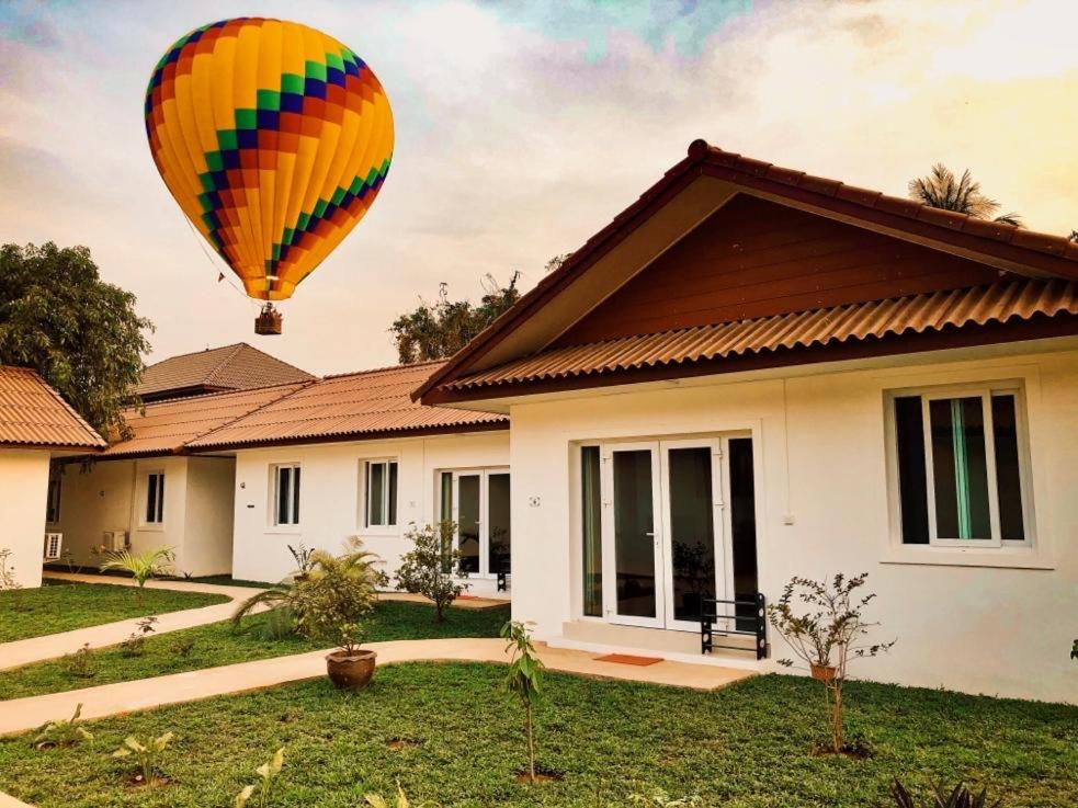 a hot air balloon flying over a house at River View Villas in Vang Vieng