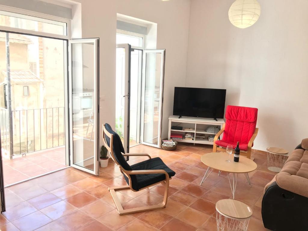 a living room with a couch and chairs and a tv at Ferienwohnung im Zentrum in Alicante