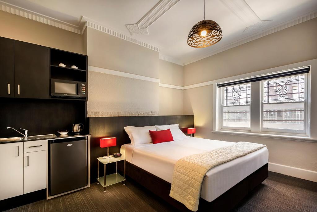 een slaapkamer met een bed en een keuken met een wastafel bij Como Court Budget Accommodation in Melbourne