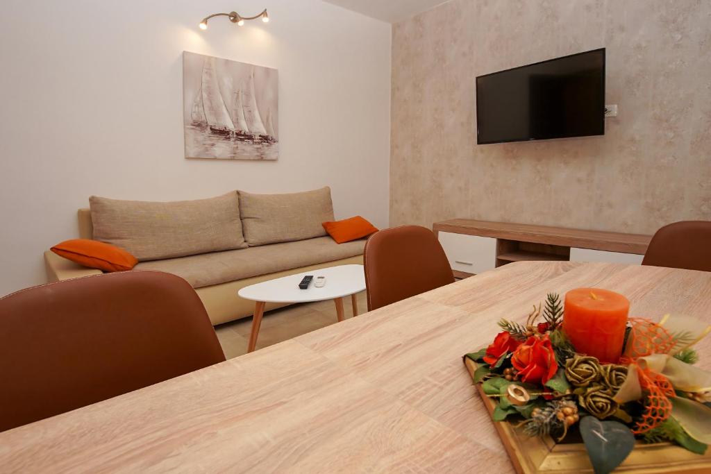 een woonkamer met een tafel en een bank bij Apartment Ajdukovic in Vodice