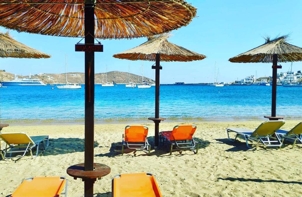 a group of chairs and umbrellas on a beach at Asteri Hotel in Livadi