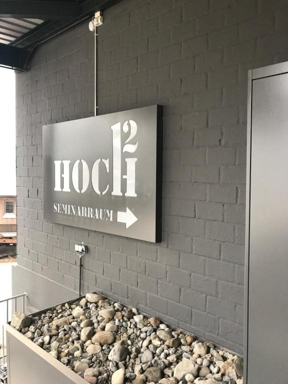um sinal para um hotel numa parede de tijolos em Easy-Living Buholz Hoch 12 em Lucerna