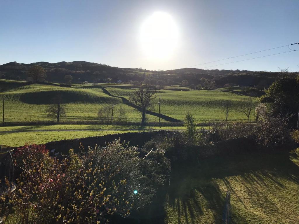 a view of a field with the sun in the background at Hillgarth Holiday House in Kendal