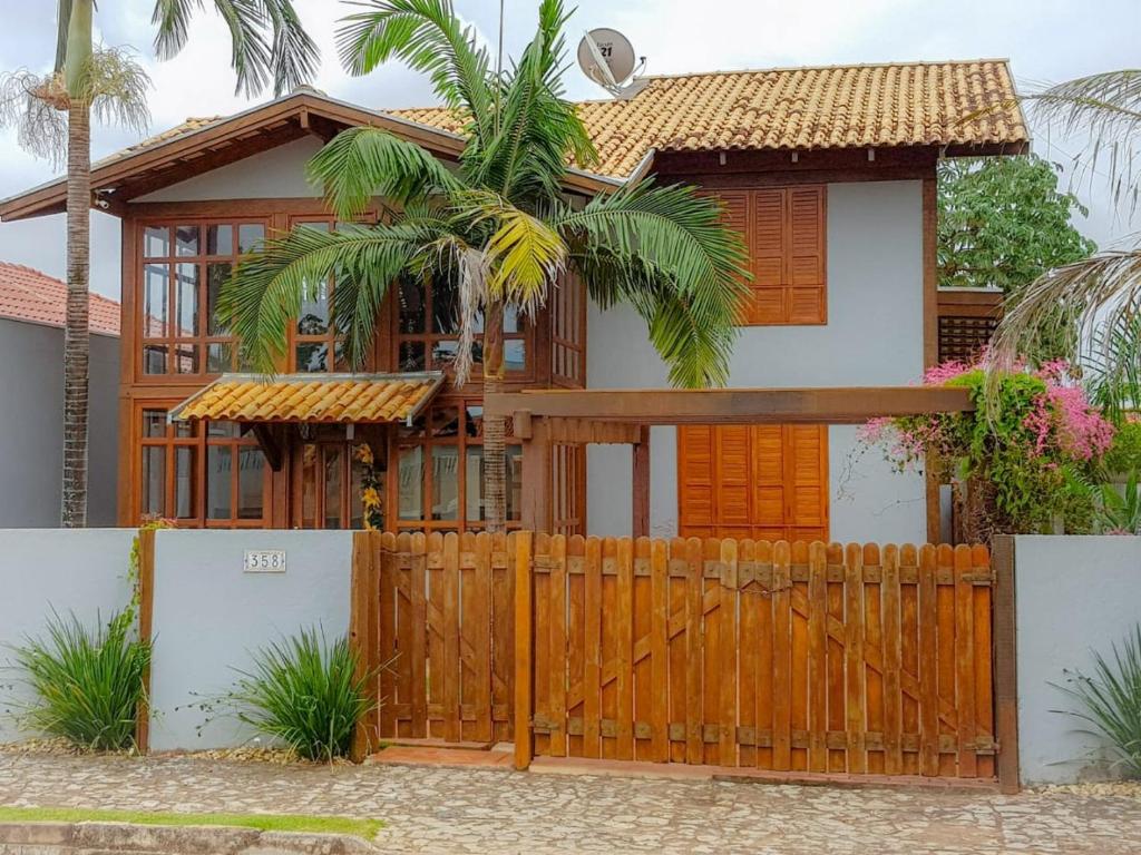 una casa con una puerta de madera y una valla en Casa com piscina, bem localizada, en Bonito