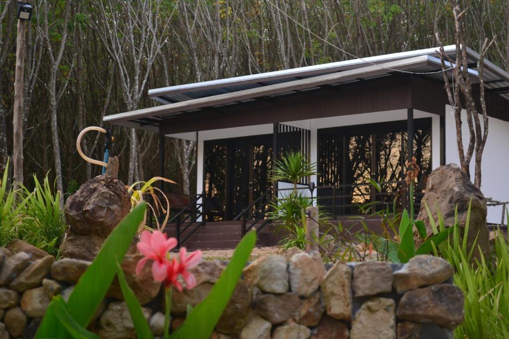 a cottage in the woods with a stone wall at Camp Hadee Koh Yao Noi in Ko Yao Noi