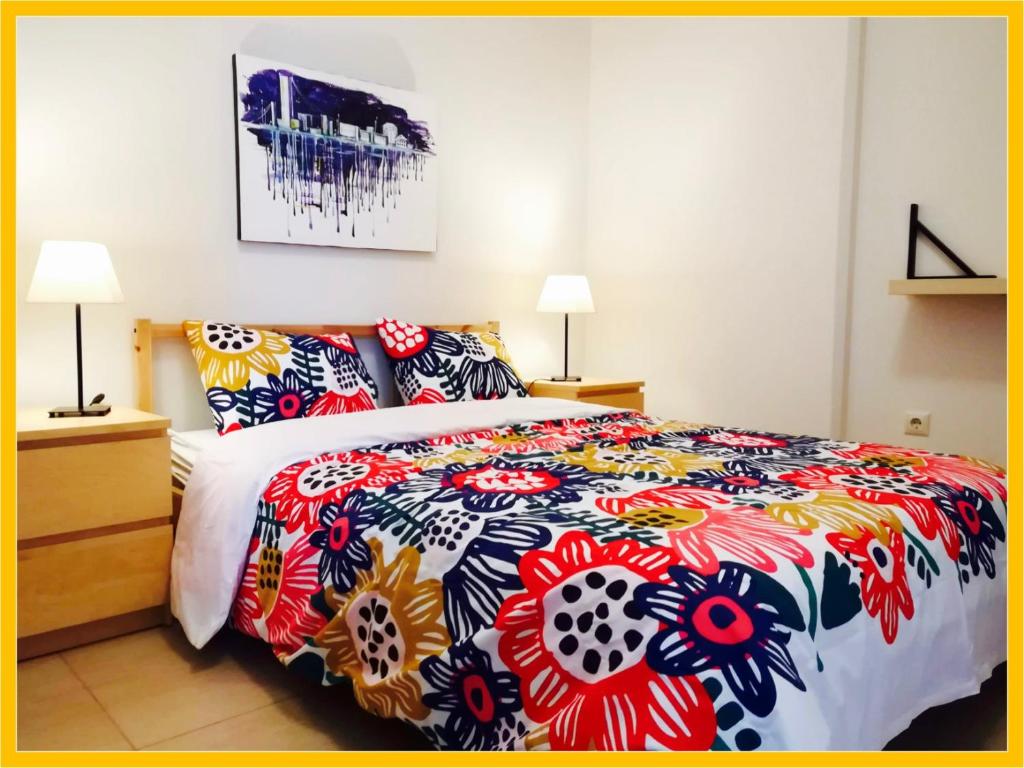 um quarto com uma cama com uma colcha colorida em Hermes Apartment - Athens Int Airport em Artemida