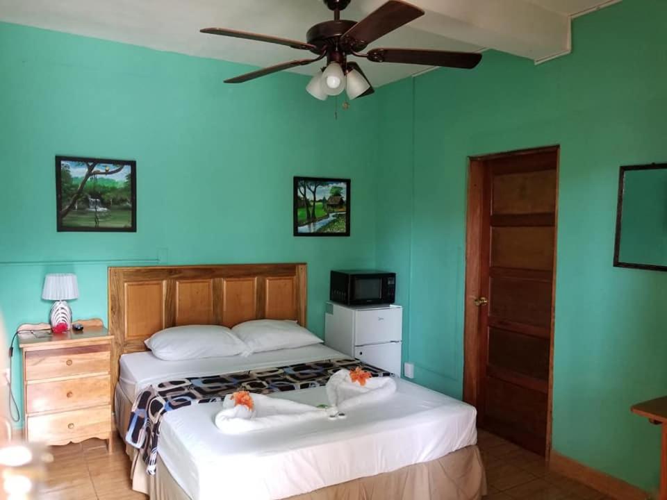 a bedroom with a bed and a ceiling fan at SAINT Charles Inn, Belize Central America in Punta Gorda
