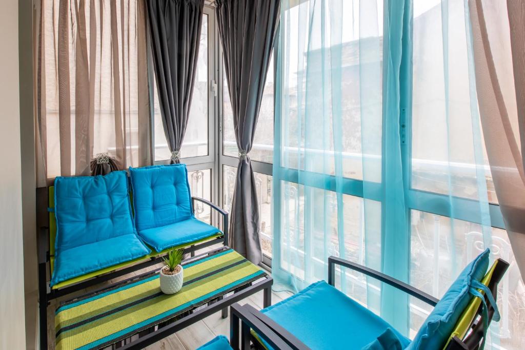 uma varanda com cadeiras azuis e uma janela em Blue Тerrace Apartment Top Center em Varna