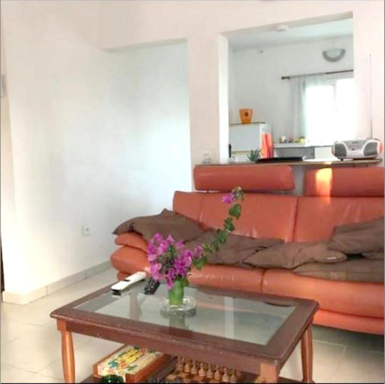 a living room with a couch and a table with flowers at Maison de 2 chambres avec vue sur la mer jardin amenage et wifi a Le Francois a 8 km de la plage in Le François