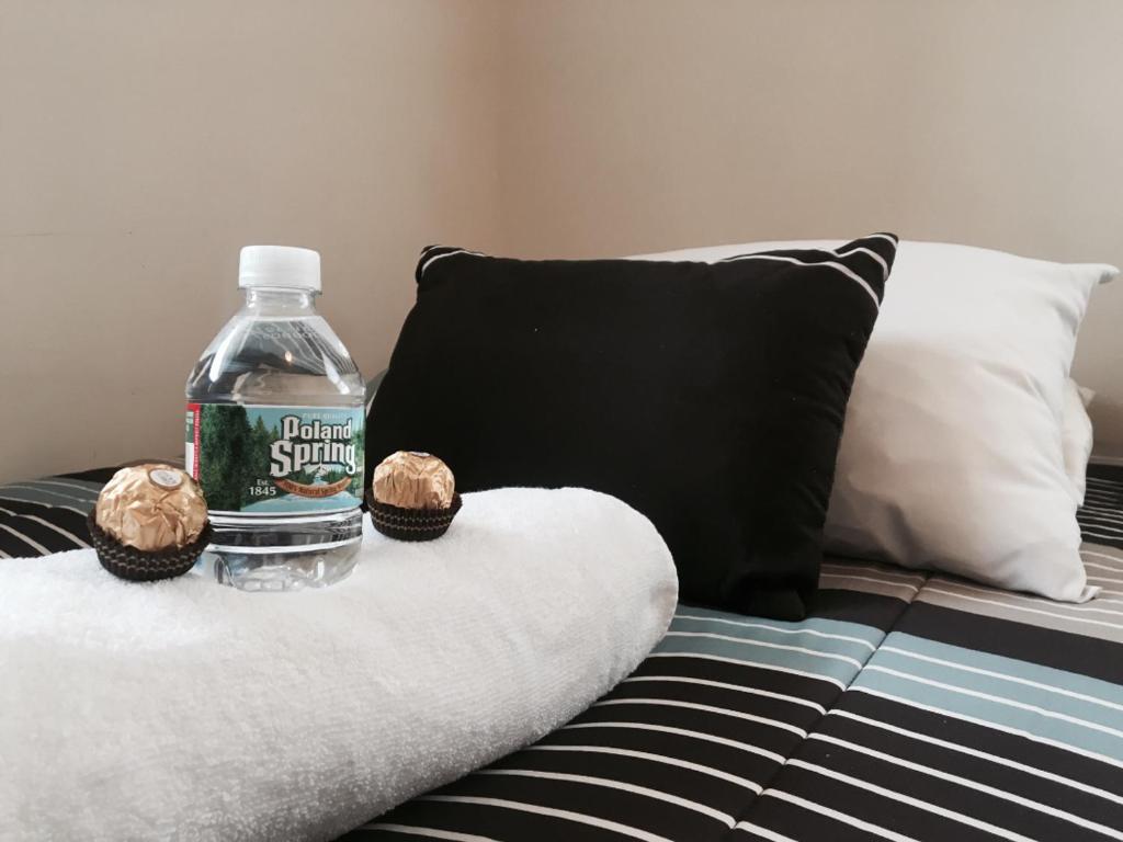 a bottle of water and two cupcakes on a bed at Cozy Private bedrooms Kitchen Wifi in Englewood