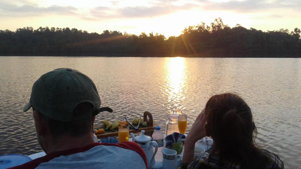 um homem e uma mulher sentados numa mesa num barco num lago em Style Villa em Bentota