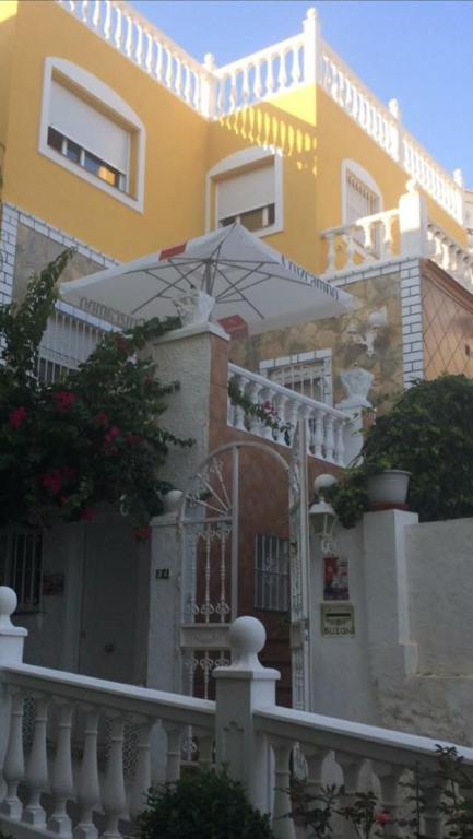 a yellow house with an umbrella in front of it at FREDOV in Benalmádena
