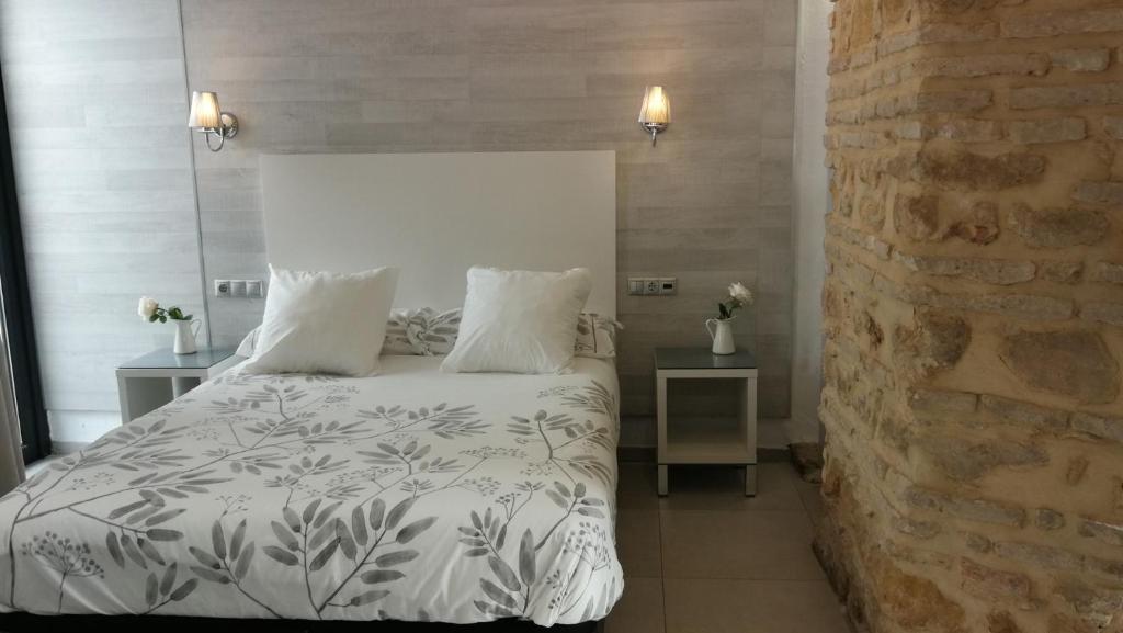 コルドバにあるPatio de la Escalera - Agustín Moreno 46の白いベッドとレンガの壁が備わるベッドルーム1室が備わります。