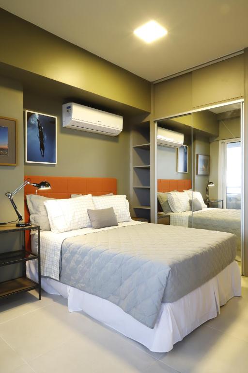 1 dormitorio con 1 cama grande y espejo en #2 Sofisticado Estúdio na Boaventura da Silva, en Belém