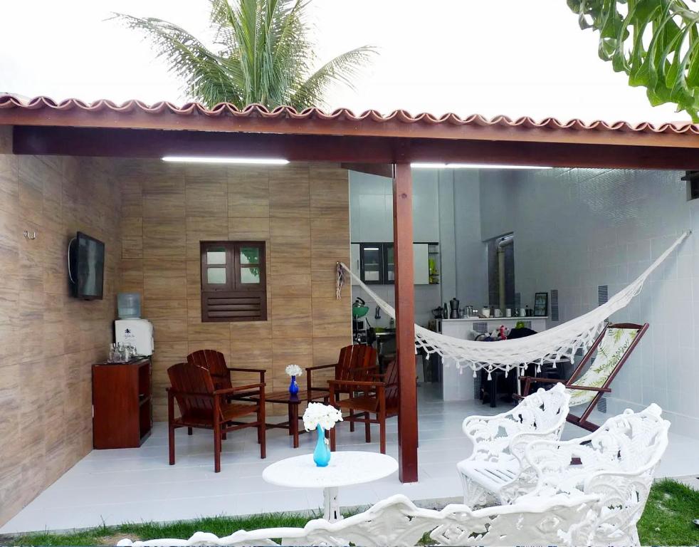 una casa con un patio con sillas y una hamaca en Casa OhVidaBoa com 6 suítes, en Natal