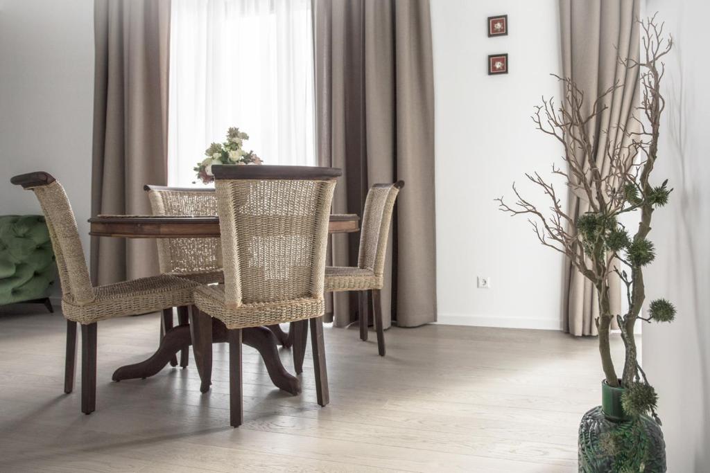 a dining room table and chairs in a room with a window at KM apartamentai in Kaunas