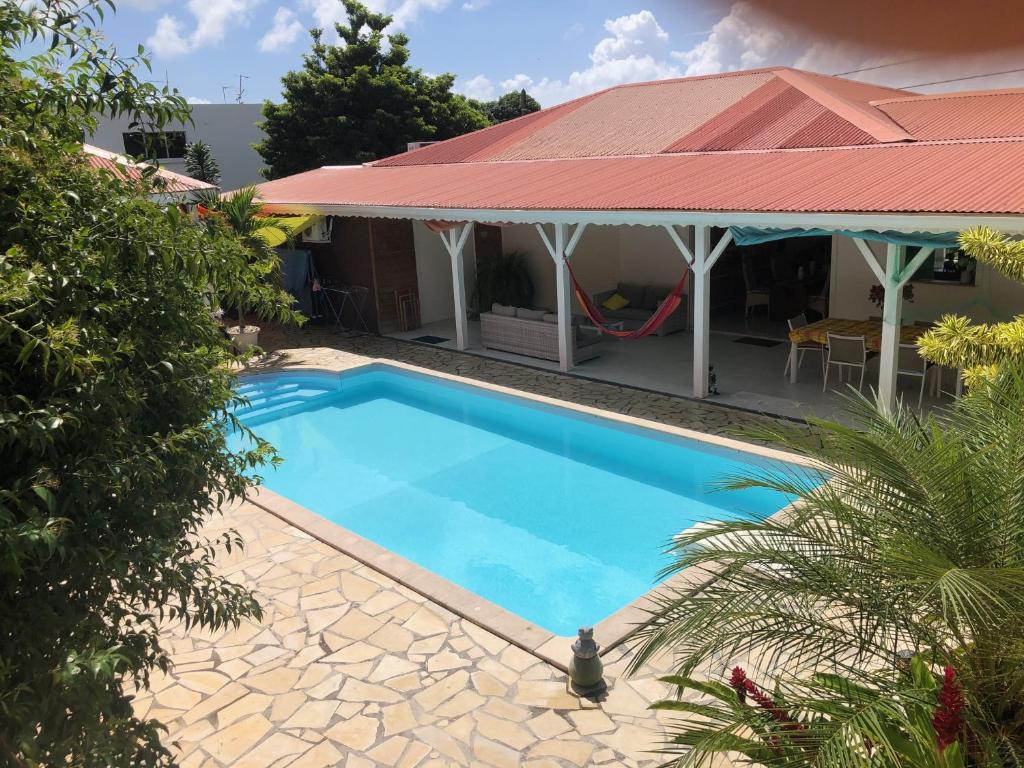 a swimming pool in front of a house at Sarithea in Basse-Terre