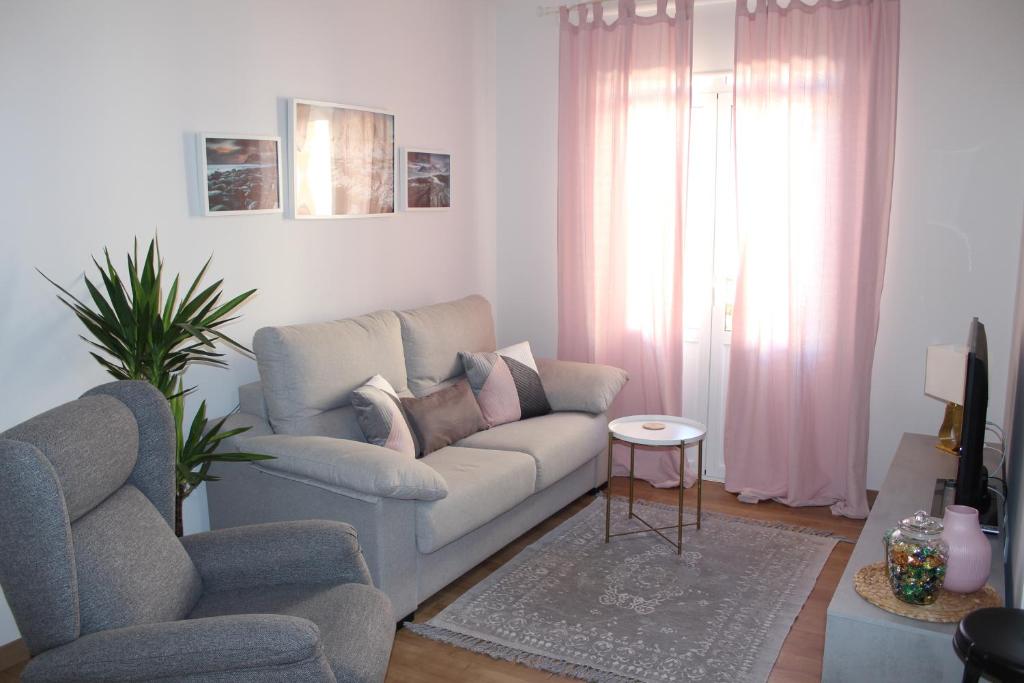 een woonkamer met een bank en een stoel bij Apartamento Botí in Cartagena