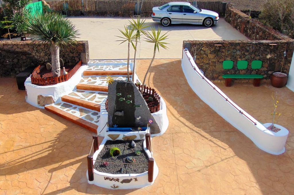 a boat with potted plants and a car in a parking lot at BUGANVILLA MOLINO in Tinajo