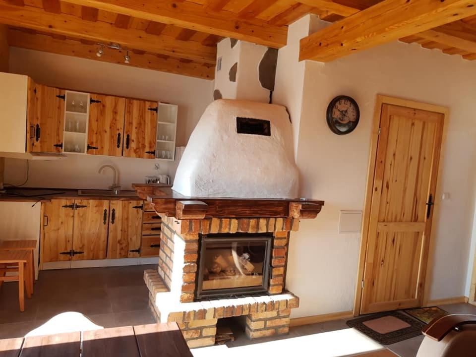 a kitchen with a stone fireplace in a room at Domek u Jawora -Agroturystyka in Grywałd