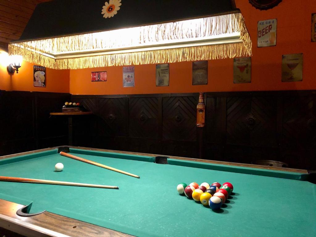 a pool table with balls and cue sticks on it at whole basemenet former pub4 stag do/hen party in Budapest