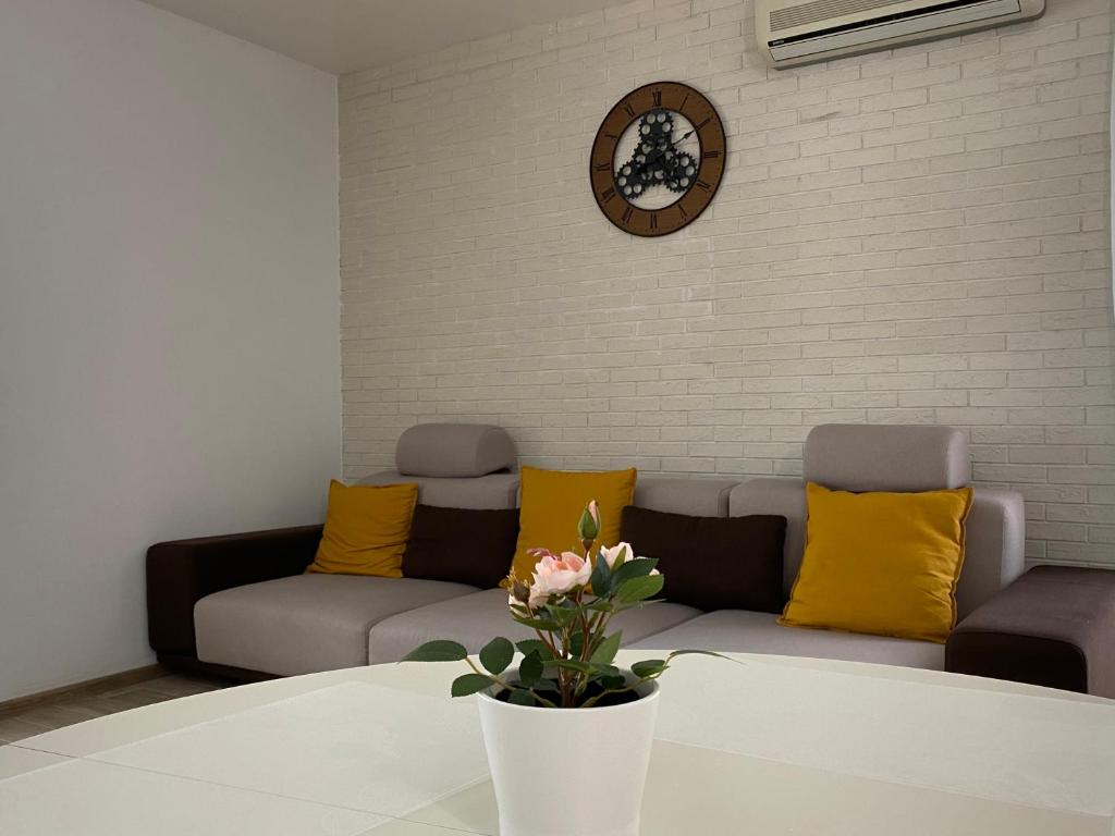 - un salon avec un canapé et une table dans l'établissement Sunny Deluxe Apartment Cosmopolis, à Ştefăneştii de Jos