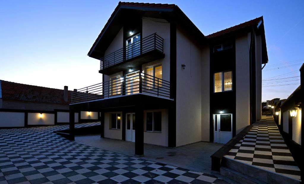 uma casa com um piso xadrez em frente em Pensiunea Natalia em Toteşti