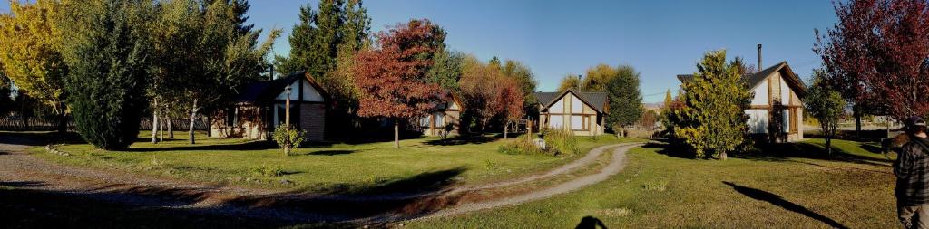 a house on a field with trees and a dirt road at Wilson Patagonia in Trevelín