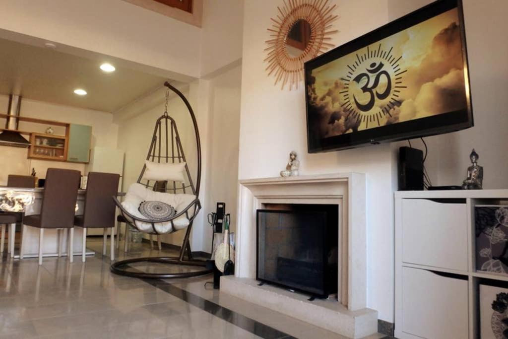 a living room with a tv and a fireplace at Pedra do Ouro Yoga Retreat apartment in Pataias