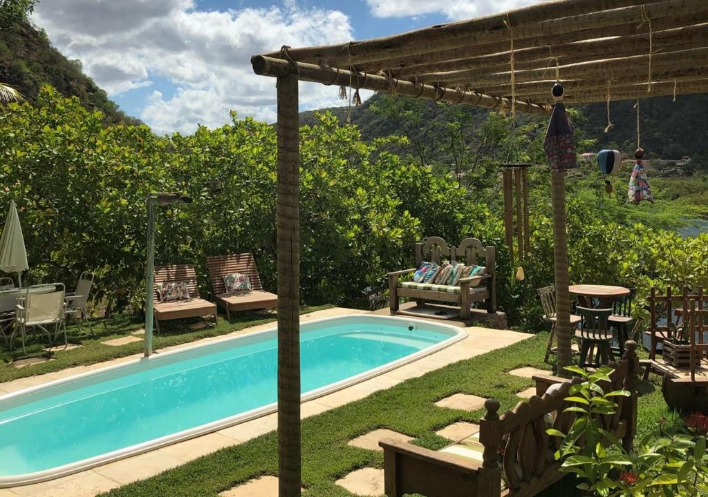 - une piscine dans une cour avec des chaises et un parasol dans l'établissement Pousada Trilha do Velho Chico, à Piranhas