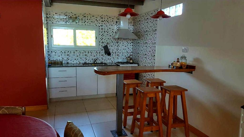 a kitchen with a counter and some stools in it at Calidez y comodidad. in General Roca