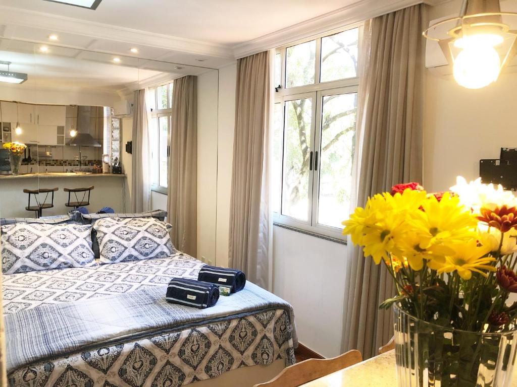 um quarto com uma cama e um vaso de flores em Comfortable & Economic no coração de Brasília em Brasília