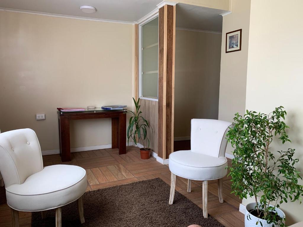 Zimmer mit 2 weißen Stühlen und einem Tisch in der Unterkunft Quimey Ruca in Freire