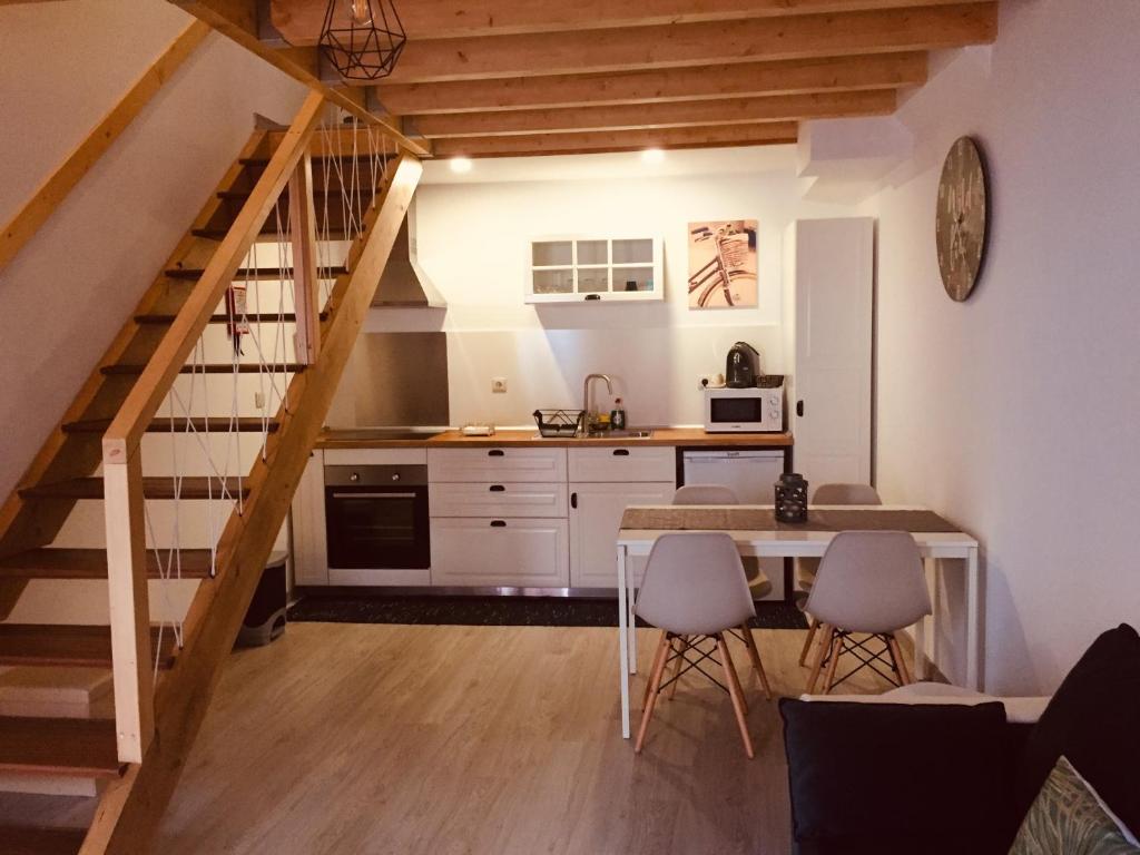 eine Küche mit einer Treppe, einem Tisch und Stühlen in der Unterkunft My Historic House 1 in Bragança