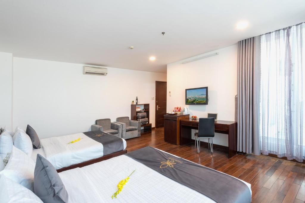 ein Hotelzimmer mit 2 Betten und einem Schreibtisch in der Unterkunft Tarasa Hotel in Đà Nẵng