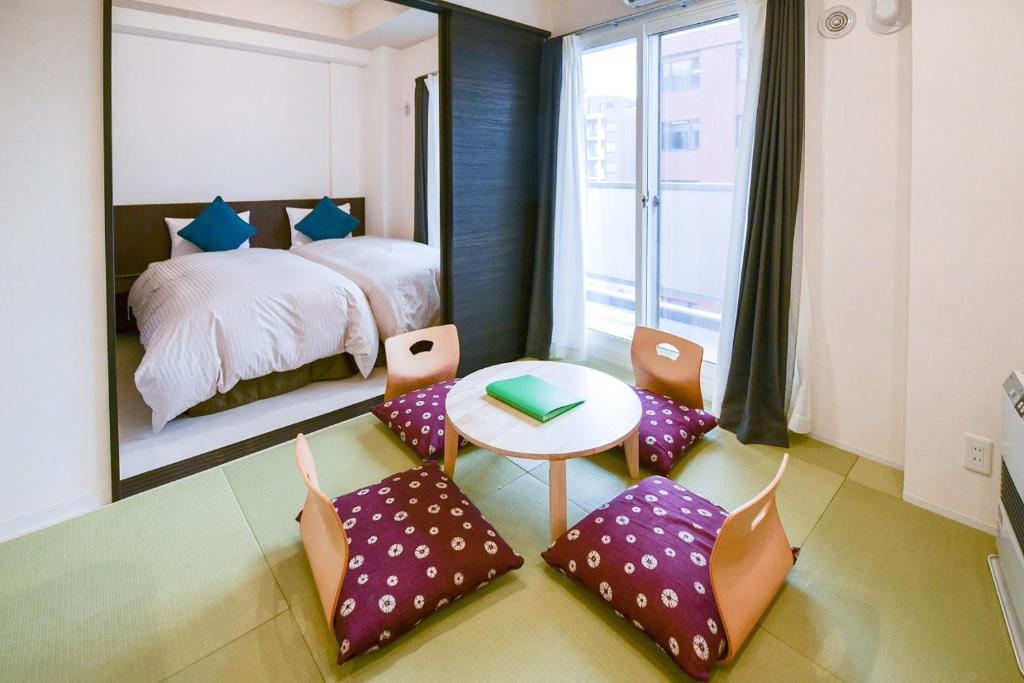 札幌市にあるmomo premium 804のベッドルーム1室(ベッド1台、テーブル、椅子付)