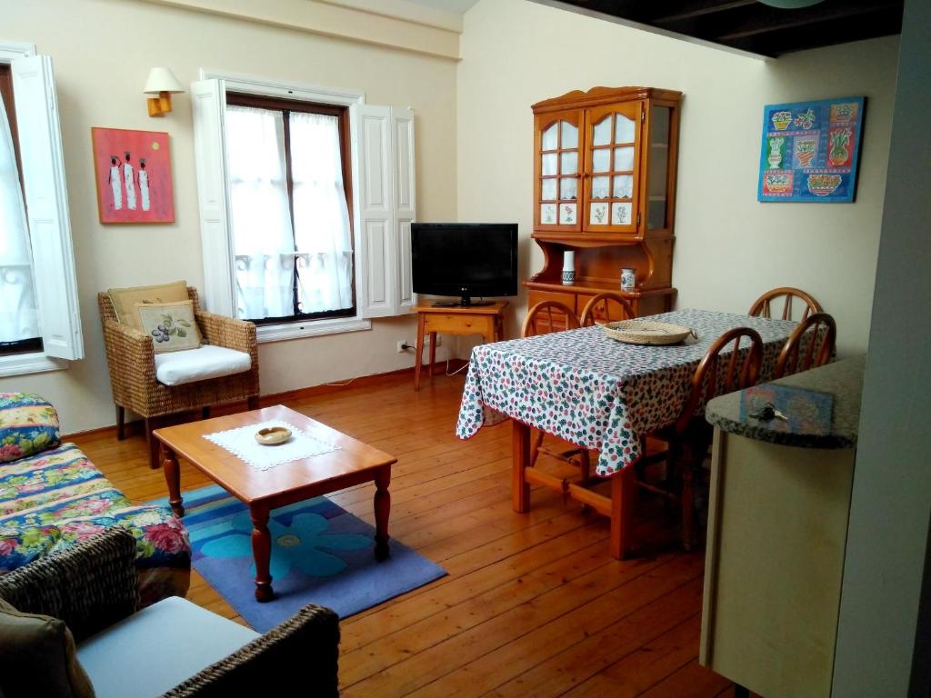 a living room with a table and chairs and a television at 2 bedrooms apartement at Llanes 200 m away from the beach with wifi in Llanes