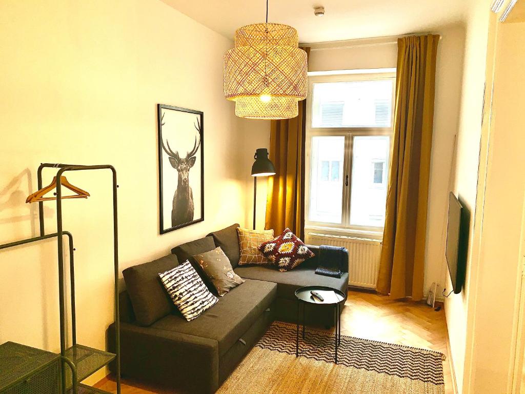 uma sala de estar com um sofá e uma janela em Contemporary City Apartment - by Nahuen Suites em Graz