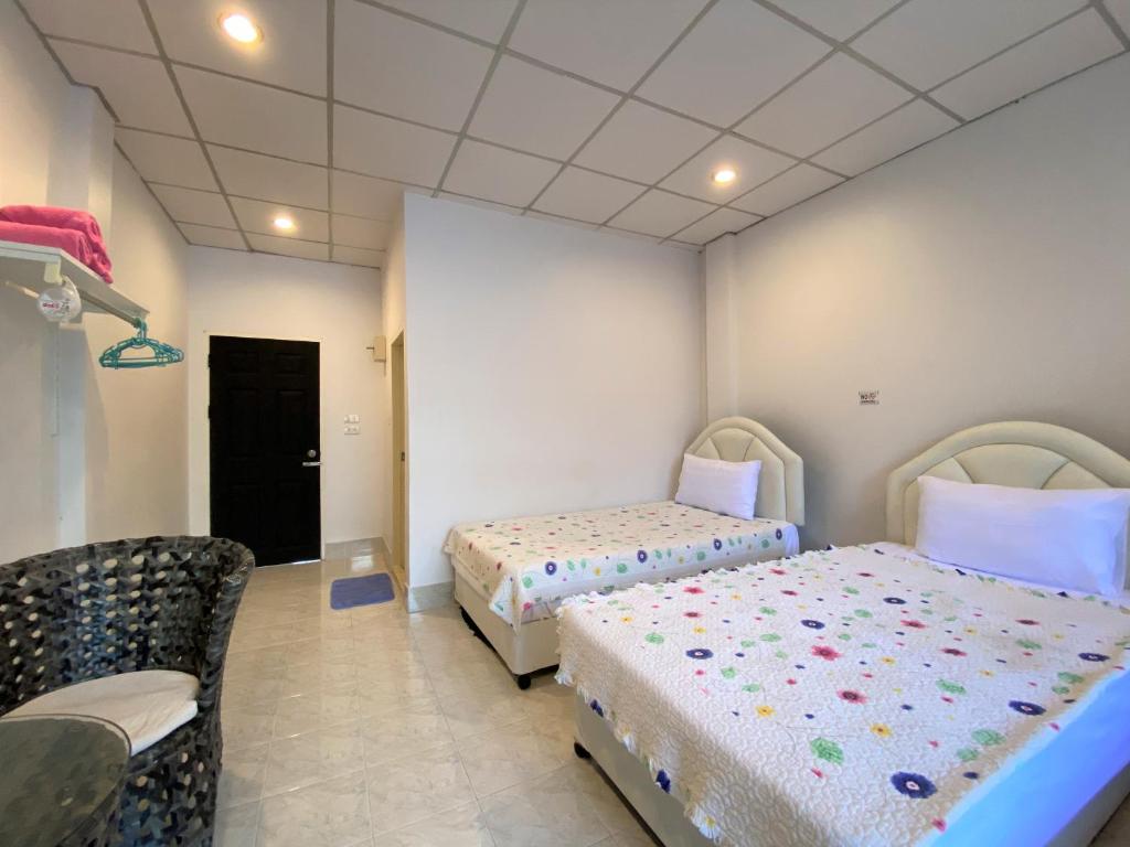 - une chambre avec 2 lits et une chaise dans l'établissement Som Guesthouse, à Patong Beach