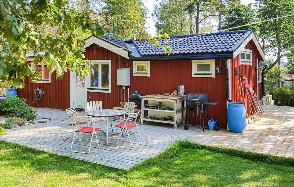 um pátio com uma mesa e cadeiras em frente a um barracão vermelho em Amazing Home In rsta Havsbad With Kitchen em Årsta Havsbad